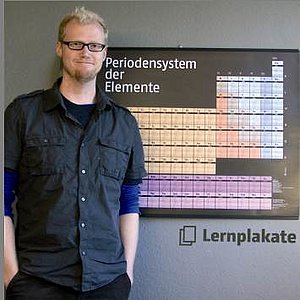 Christian Büning vor seinem Lernplakat zum Periodensystem.