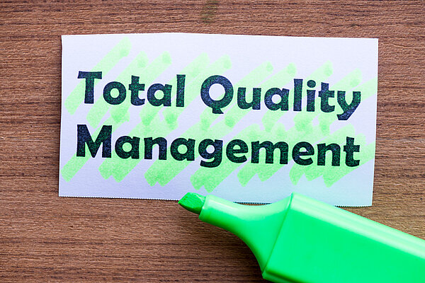 Erklärung des Begriffs TQM Total Quality Management Schild mit Begriff TQM Total Quality Management