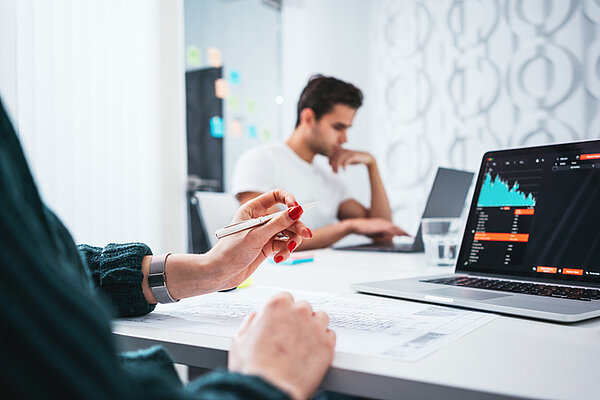 Kollegen sitzen vor dem Laptop und optimieren