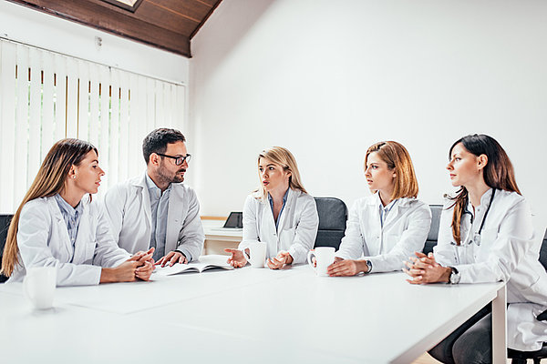 Eine Gruppe mit Ärzten am Tisch